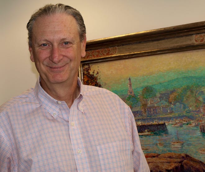 Financial advisor David Grey has been mentoring boys in Gloucester for Children’s Friend and Family Services for seven years. Here he stands in front of one of his many paintings of the Gloucester waterfront. Wicked Local Photo by Deborah Gardner Walker