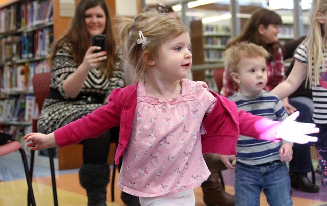 Rachel Rodemann Times Record Lillian Graves, 2, dances around the Van Buren Public Library while her mother, Leanna Graves films her, Wednesday, Feb. 26, 2014, during toddler story time at the library. Lillian is the daughter of Leanna and Toby Graves.