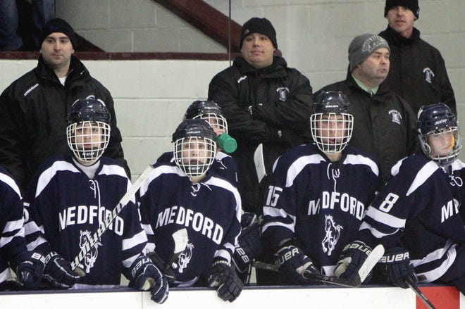 Medford High Boys Hockey Head Coach Sean Bates, second from left, watched the action from behind the bench, during Division 1 North State Tournament action with Wilmington, March 1, at the Chelmsford Forum. Wilmington won the game in double OT 1-0. Wicked Local Staff Photo / Nicole Goodhue Boyd