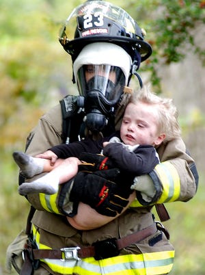 This photograph taken by Havelock News reporter/photographer Drew C. Wilson of a firefighter carrying a rescued child away from a house fire won a first-place award from the N.C. Press Association Thursday in Chapel Hill.