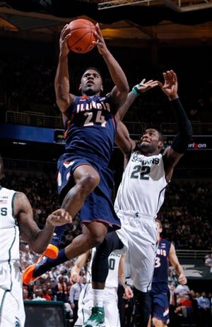 Illinois' Rayvonte Rice (24) goes up for a fast-break layup in front of Michigan State's Branden Dawson during the first half of an NCAA college basketball game on Saturday, March 1, 2014, in East Lansing, Mich. Illinois won 53-46. (AP Photo/Al Goldis)