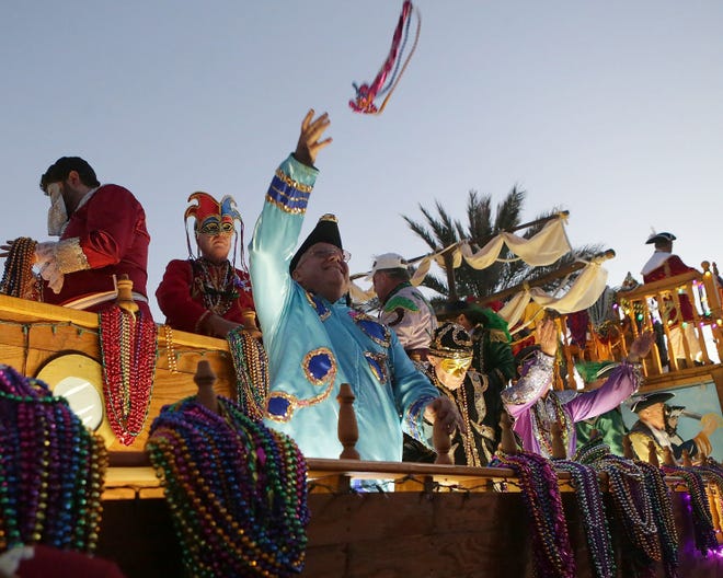 Gentlemen in nautical costumes throw beads during the Panama City Beach Mardi Gras Parade at Pier Park on Saturday.