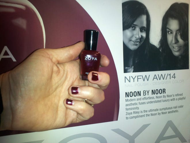 Models sport a deep red color with a half moon design at the base of the nail.
