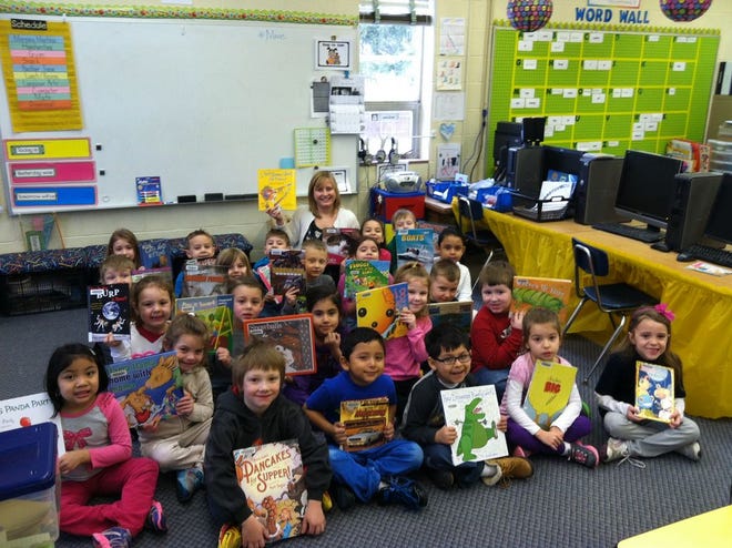 Christina Tylka and her kindergarten students at Genoa Elementary School show off some of their favorite books.