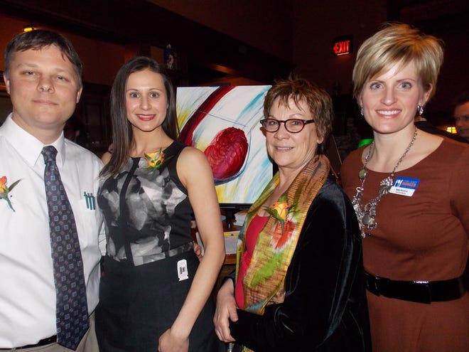 Jon and Elizabeth Jacob (left) help host the Guest Sommelier Night event at Bender's Tavern recently for which local artist, Su Nimon (second from right) painted this acrylic artwork to raise money for the event to support the Stark County Hunger Task Force. Amy Weisbrod is executive director of the task force.