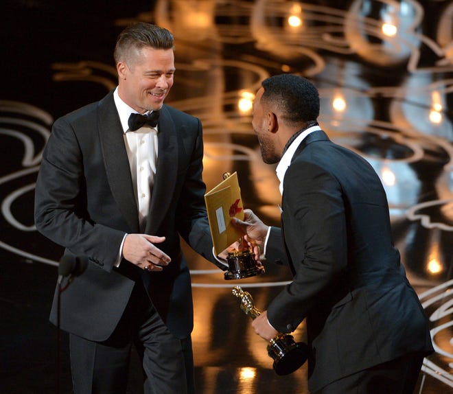 Will Smith, right, presents Brad Pitt with the award for the best picture for "12 Years a Slave" during the Oscars at the Dolby Theatre on Sunday, March 2, 2014, in Los Angeles. THE ASSOCIATED PRESS