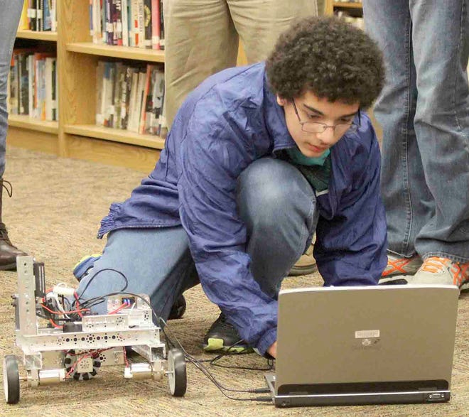 Alex Arias sets up his team's robot for a demonstration. CHRIS WORST PHOTO.