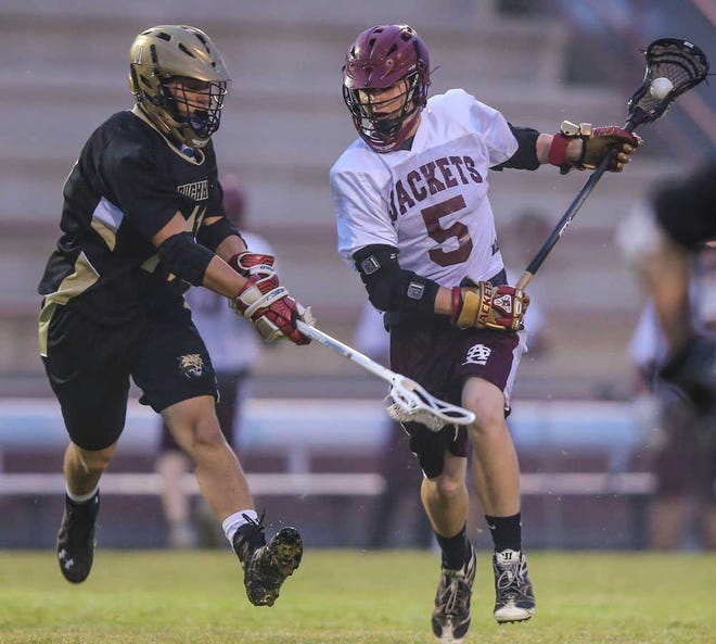 St. Augustine's Jeremy Harmon (5) drives to the goal defended by Buchholz 's Reggie Sheffield (11) during first half high school boys' lacrosse action at St. Augustine High School, St. Augustine, Fla., Tuesday, March 4, 2014. By GARY McCULLOUGH / CORRESPONDENT