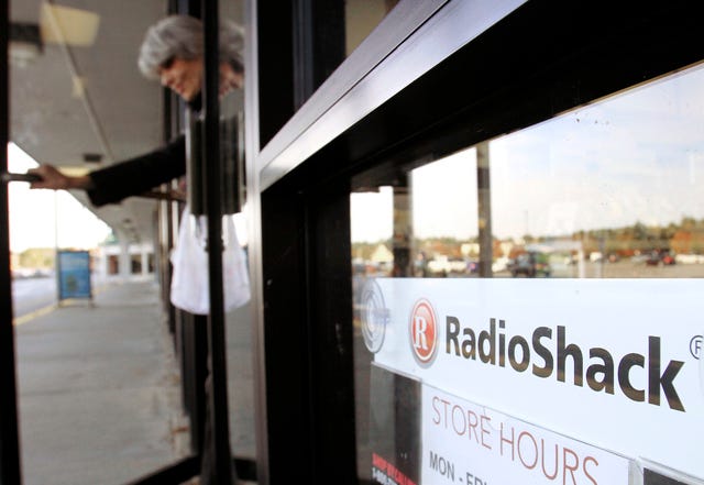 ASSOCIATED PRESS FILE PHOTO / A shopper leaves a RadioShack store in Brunswick, Maine, in October 2010. Electronics retailer RadioShack Corp. on Tuesday said it plans to close up to 1,100 of its under-performing stores in the U.S. and reported a wider loss for its fourth quarter as traffic slowed during the critical holiday season.