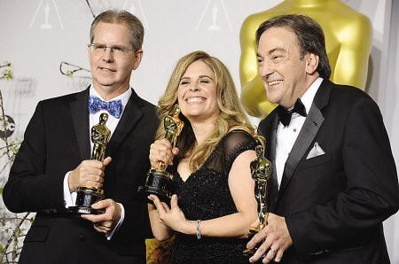 From left, Chris Buck, Jennifer Lee and Peter Del Vecho pose in the press room with the award for best animated feature film of the year for "Frozen" during the Oscars at the Dolby Theatre on Sunday in Los Angeles.