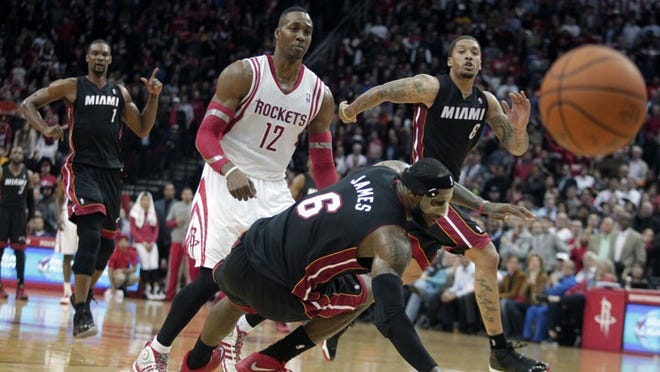 Miami Heat forward LeBron James (6) falls to the ground after colliding with Houston Rockets center Dwight Howard (12) during the fourth quarter of an NBA basketball game, Tuesday, March, 4, 2014, in Houston. The Rockets defeated the Heat 106-103. (AP Photo/Patric Schneider)