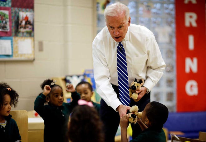 Vice President Joe Biden passes out stuffed animals while visiting children in a classroom at the East Lake Family YMCA, Tuesday, March 4, 2014, in Atlanta. Biden is campaigning and raising money around the country for Democrats in the 2014 midterm elections. Many of his stops are in states, like Georgia, where President Barack Obama is unpopular among white voters. (AP Photo/David Goldman)