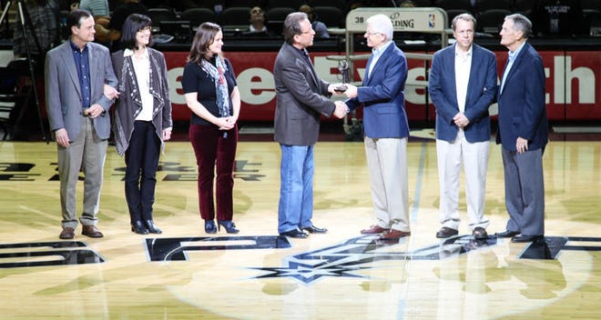 Dr. Bill Ellis (third from right), HPU president, and members of the Cowden family presented Kevin Dinnin of San Antonio (fourth from left) with the Gordon Ware Cowden Courage in Christianity Award at the start of the San Antonio Spurs basketball game on March 2.