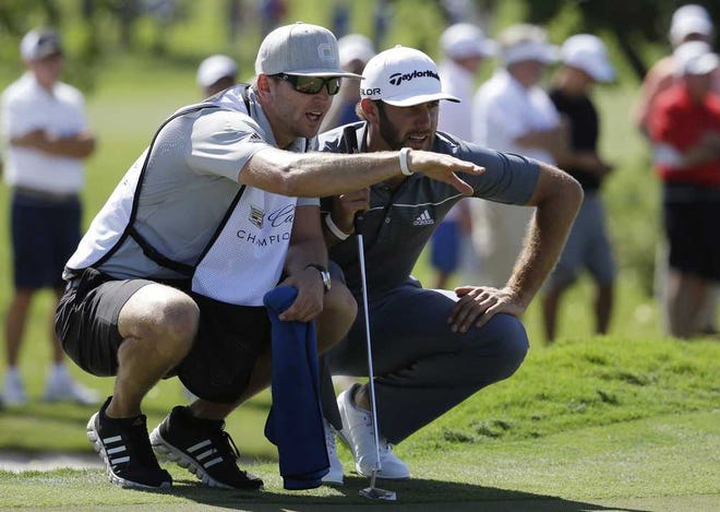 Dustin Johnson, right, listens to his caddie and brother Austin Johnson on the sixth hole during the second round of the Cadillac Championship golf tournament on Friday, March 7, 2014, in Doral, Fla. (AP Photo/Lynne Sladky)