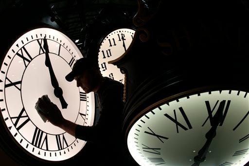 Dave LeMote wipes down a post clock at Electric Time Company, Inc. in Medfield, Mass., Friday, March 7, 2014. Most Americans will set their clocks 60 minutes forward before heading to bed Saturday night, but daylight saving time officially starts Sunday at 2 a.m.