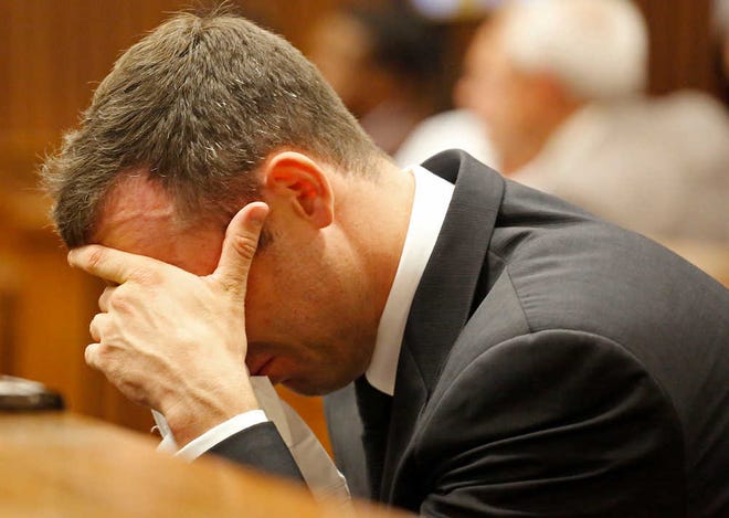 Oscar Pistorius puts his hand to his face as he listens to cross questioning about the events surrounding the shooting death of his girlfriend Reeva Steenkamp, in court during his trial in Pretoria, South Africa, Friday, March 7, 2014. Pistorius is charged with murder for the death Steenkamp, on Valentines Day in 2013. (AP Photo/Schalk van Zuydam, Pool)