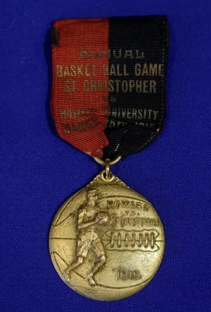 In this Feb. 19, 2014 photo, a souvenir medallion for a basketball game played between Howard University and St. Christopher is part of an exhibit entitled "The Black Fives," at the New-York Historical Society in New York. Dozens of teams flourished between 1904 and 1950 in what became known as the Black Fives Era, an often-overlooked piece of black history that is the subject of an exhibition opening at the New-York Historical Society on March 14.