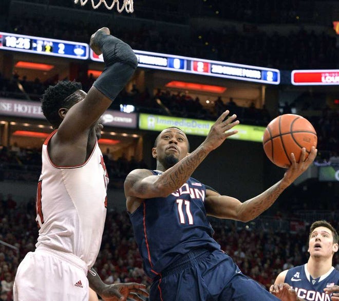 Connecticut's Ryan Boatright, right, attempts a shot over the defense of Louisville' Montrezl Harrell during the first half of an NCAA college basketball game, Saturday, March 8, 2014, in Louisville, Ky. (AP Photo/Timothy D. Easley)