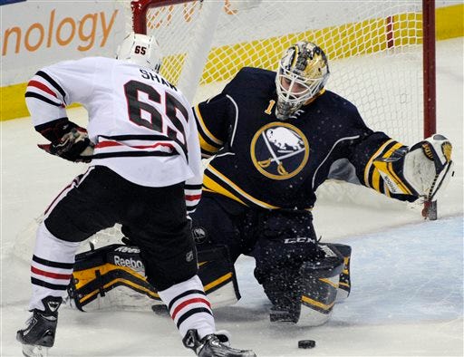Chicago Blackhawks center Andrew Shaw (65) battles for a rebound from Buffalo Sabres goaltender Jhonas Enroth (1), of Sweden, during the third period of an NHL hockey game in Buffalo, N.Y., Sunday, March 9, 2014. Chicago won 2-1.