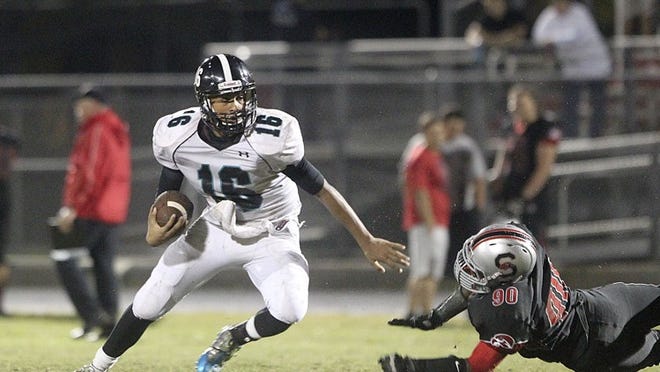 Royal Palm’s Toddy Centeio eludes Seminole Ridge’s Allimu Adelalkun for a gain during a game on November 8, 2013. Centeio had an impressive freshman season and was named MVP of the Mastrole Super 7 QB Challenge in December. (Damon Higgins/The Palm Beach Post)