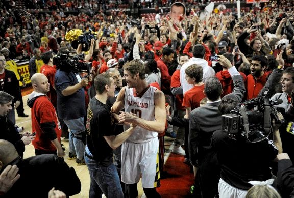 AP PHOTO
Maryland's Jake Layman (10) celebrates with the crowd after fans rushed the floor after beating Virginia 75-69 in overtime Sunday in College Park, Md.