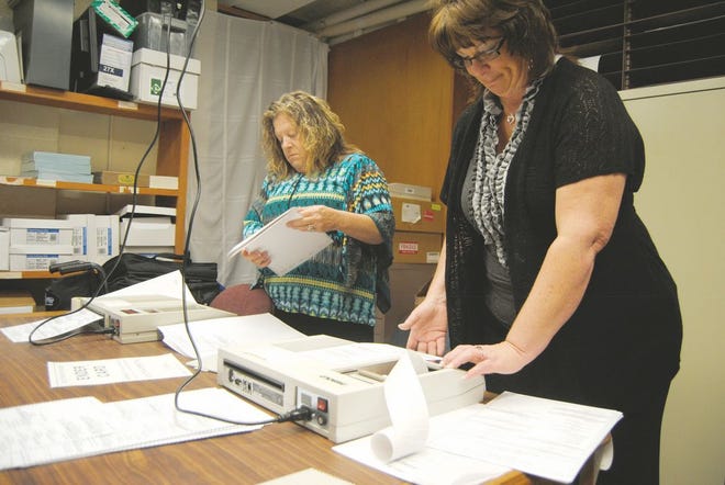 McDonough County Clerk Gretchen DeJaynes and her assistant Jackie Metcalf test voting machines.