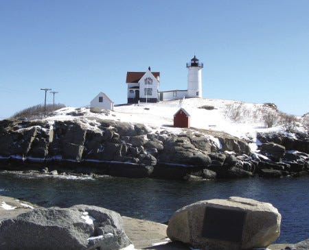 Nubble Light attracts visitors year-round. In winter the landmark's grassy landscape is covered in white.