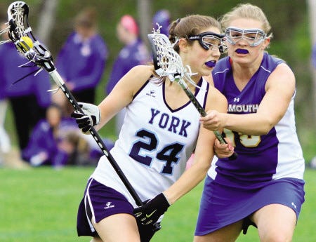 York High School's Courtney Cole is defended by Falmouth's Maddie Scop during last year's Western Maine Class B quarterfinal girls lacrosse game. Cole scored the game-winning goal as the Wildcats won their first playoff game in program history.