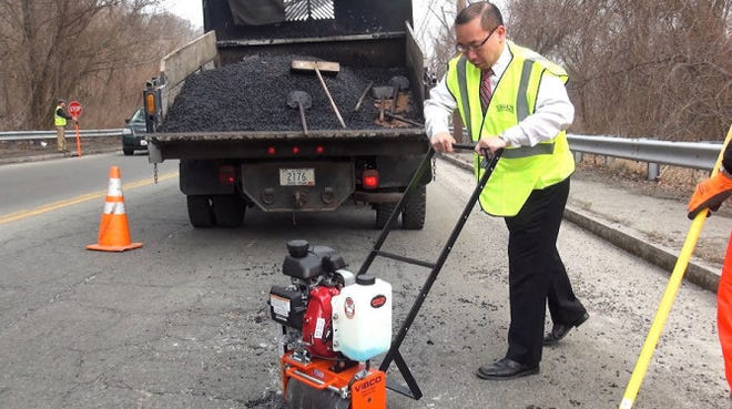 Cranston Mayor Allan Fung tries out the Vibco roller. Karl Wadensten, owner and president of VIBCO Vibrators — a Rhode Island-based company that makes industrial vibrators — said he will give his machinery to every municipality that wants to repair its potholes.