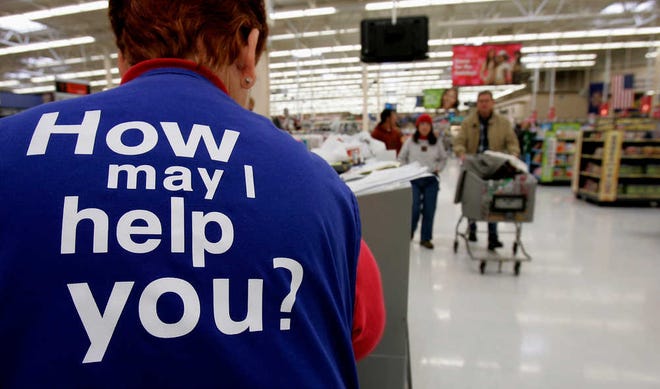 FILE - In this Sunday, Nov. 13, 2005, file photo, customers at a Wal-Mart store head to the checkout lines past a worker with the company's motto on the back of her vest, in Salt Lake City. With fewer middle-income jobs available, low-wage work is becoming a dead-end for more Wal-Mart employees. (AP Photo/Douglas C. Pizac, File)