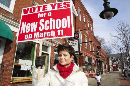 At the polls on Tuesday, Joanne Reynolds of Newmarket shows her support for a the $45 million new school project defeated by voters on Election Day.