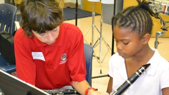 Oxbridge Academy’s Tri-M Music Honor Society member Eric Garcia (left) works with Shaniya Jackson from the North Palm Beach Elementary Children’s Orchestra and Performing Arts Choice Program. The mentoring program was conceived by Garcia, who began working with elementary age musicians while at Bak Middle School of the Arts.