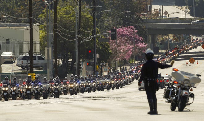 A motorcade of Los Angeles police officers escorts the casket of Nicholas Choung Lee after his funeral Mass yesterday in Los Angeles. The police officer, 40, died last Friday when the squad car he and his partner were in collided with a trash truck.