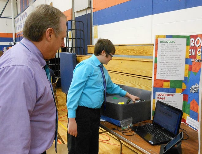 Griffin Shenkel shows how his robot works to Tom Renz, a judge, during the 26th Annual Poland Central School Science Fair on March 6. TELEGRAM FILE PHOTO