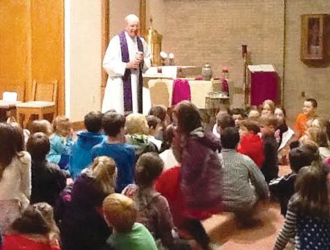 Father Dennis O’Brien speaks with the children of the parish.