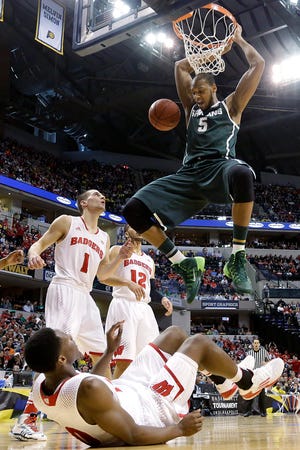 Michigan State forward Adreian Payne (5) dunks over Wisconsin forward Nigel Hayes, bottom, in the first half of an NCAA college basketball game in the semifinals of the Big Ten Conference tournament Saturday, March 15, 2014, in Indianapolis. (AP Photo/Michael Conroy)