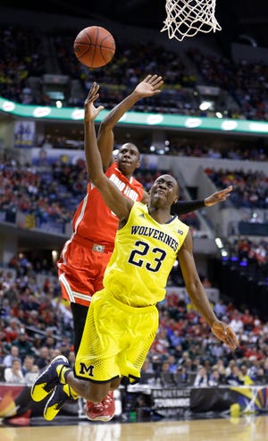 Michigan guard Caris LeVert (23) shoots against Ohio State guard Shannon Scott (3) in the first half of an NCAA college basketball game in the semifinals of the Big Ten Conference tournament Saturday, March 15, 2014, in Indianapolis. (AP Photo/Michael Conroy)