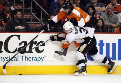 Philadelphia Flyers' Sean Couturier, top, and Pittsburgh Penguins' Olli Maatta battle for the puck along the boards during the second period of an NHL hockey game, Saturday, March 15, 2014, in Philadelphia. (AP Photo/Tom Mihalek)