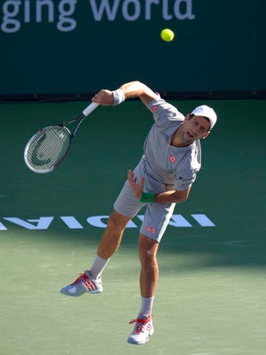Novak Djokovic serves to Roger Federer in the title match of the BNP Paribas Open in Indian Wells, Calif. on Sunday.