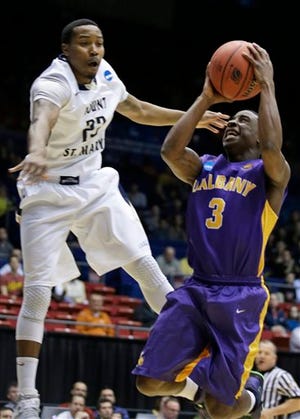 Albany guard DJ Evans (3) drives against Mount St. Mary's guard Julian Norfleet in the first half of a first-round game of the NCAA college basketball tournament, Tuesday, March 18, 2014, in Dayton, Ohio. (AP Photo/Al Behrman)