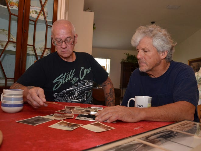 Tom Szymecki, left, and Toby Finney, share memories through some of Finney's photos from the past, as the two Vietnam veterans got together for coffee last Wednesday, in Ocala.