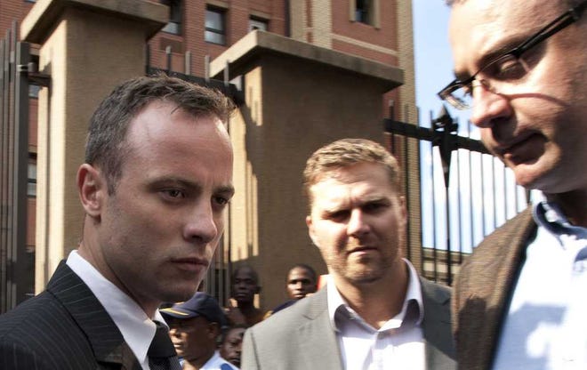 Oscar Pistorius, accompanied by relatives, leaves the high court in Pretoria, South Africa, Tuesday, March 18, 2014. Pistorius is charged with murder for the shooting death of his girlfriend, Reeva Steenkamp, on Valentines Day in 2013. (AP Photo/Themba Hadebe)