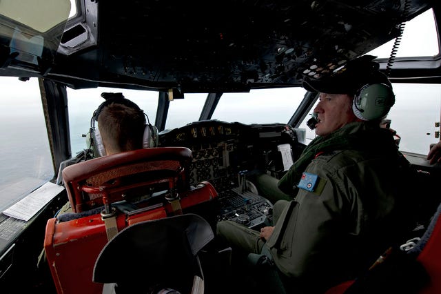 THE ASSOCIATED PRESS / A photo released by the Australia Defense Department shows Warrant Officer Ron Day, a Royal Australian Air Force flight engineer, on board an AP-3C Orion over the Southern Indian Ocean off the Western Australian coast during a search operation Wednesday for missing Malaysian Airlines flight MH370.
