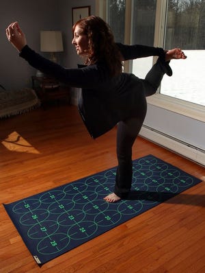 In this photo, Elizabeth Morrow poses on her specially designed Yoga by Numbers mat. The mat gives true yoga beginners a step-by-step roadmap to learn poses at their own pace.