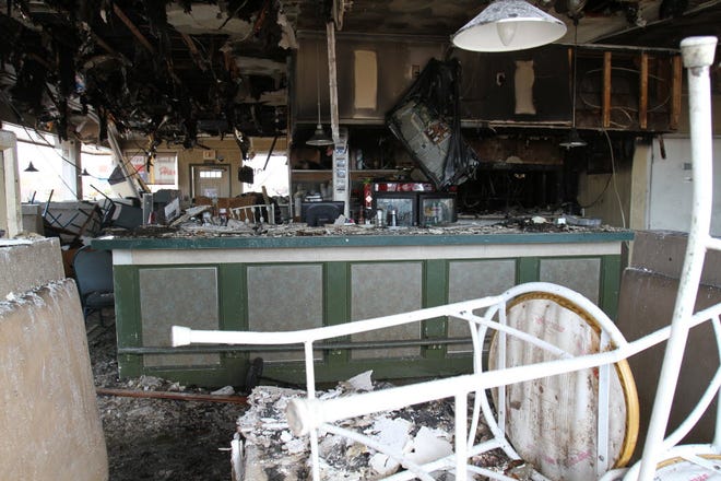 The interior of the diner, as seen through a window, shows more damage.