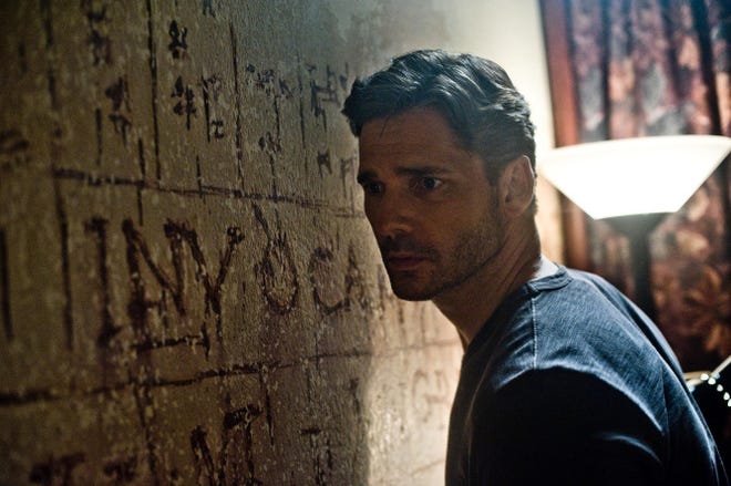 Ralph Sarchie, played by Eric Bana, studies bizarre words and symbols and hears strange sounds from behind a wall in "Deliver Us From Evil."