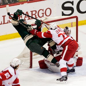 Minnesota Wild left wing Zach Parise (11) is checked hard by Detroit Red Wings defenseman Kyle Quincey (27) during the first period on Saturday in St. Paul, Minn. (AP Photo/Paul Battaglia)