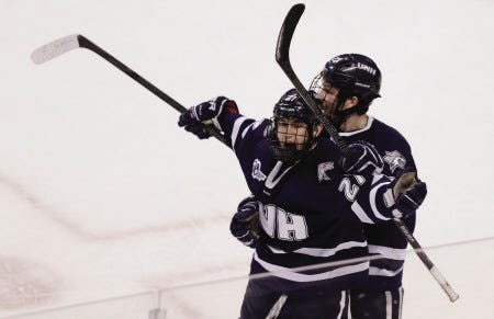 New Hampshire center Kevin Goumas celebrates his goal against Providence with teammate Brett Pesce, right, during the second period of a Hockey East college playoff game Friday, March 21, 2014, in Boston. (AP Photo/Charles Krupa)