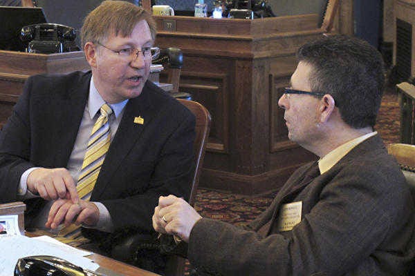 Kansas state Rep. Pete DeGraaf, left, a Mulvane Republican, confers with Rep. Jim Howell, a Derby Republican, during a House debate.