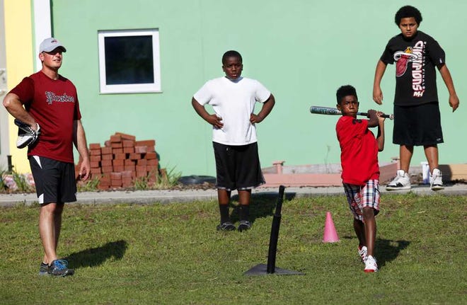 DARON.DEAN@STAUGUSTINE.COM Jae'kwaun Smiley, 10, watches his hit as Pete McKendrick, left, stands nearby at the Boys and Girls Club Thursday afternoon, March 20, 2014.DARON.DEAN@STAUGUSTINE.COM
